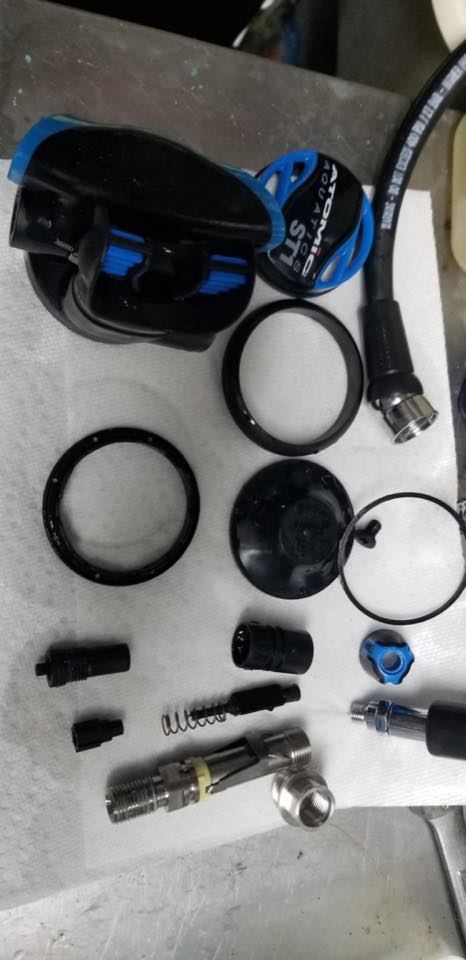 A regulator second stage taken apart with every part laid out on the bench