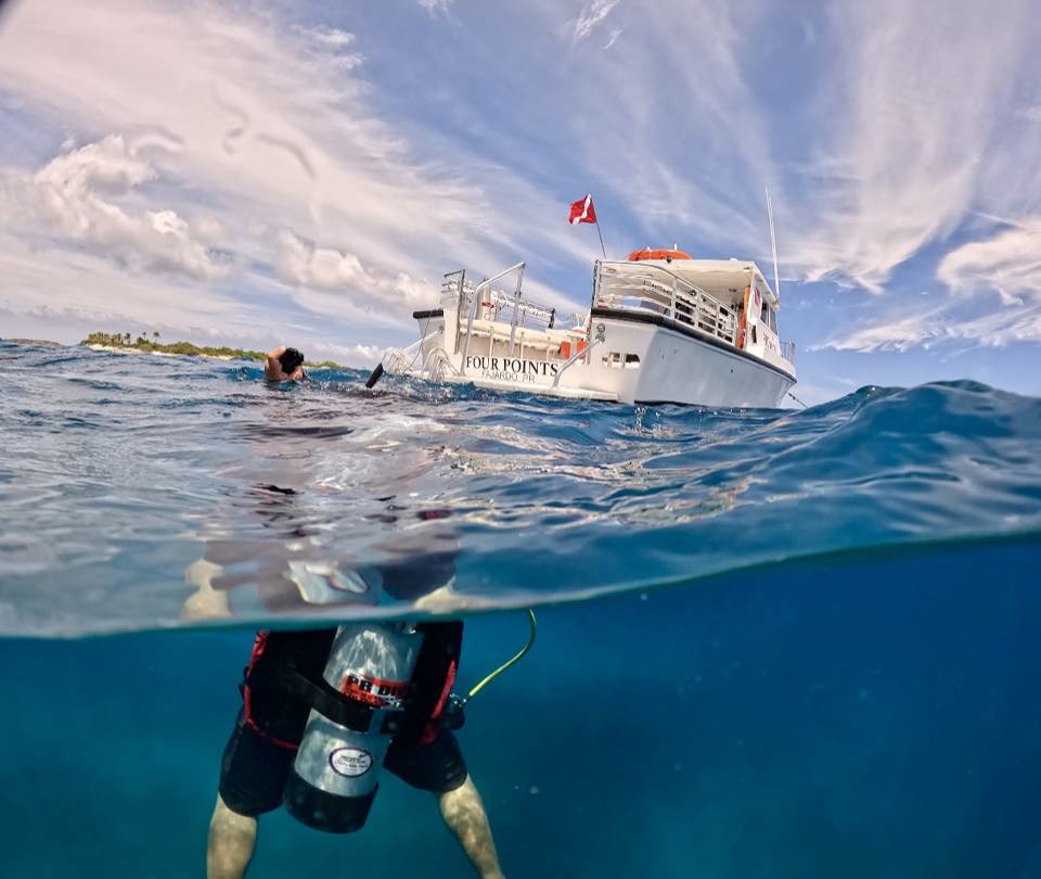 A diver at the surface next to the dive boat Four Points