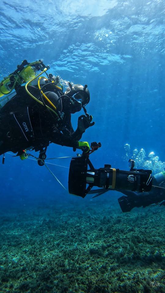 A diver riding an underwater scooter over the reef
