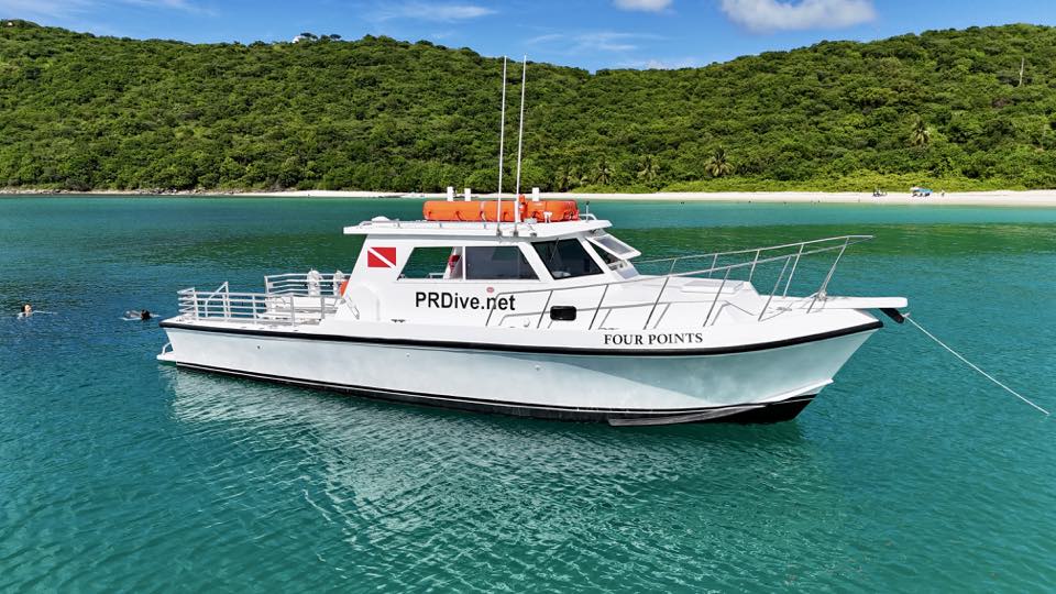 Four Points, PR Dive’s dive boat, in clear water off a beach