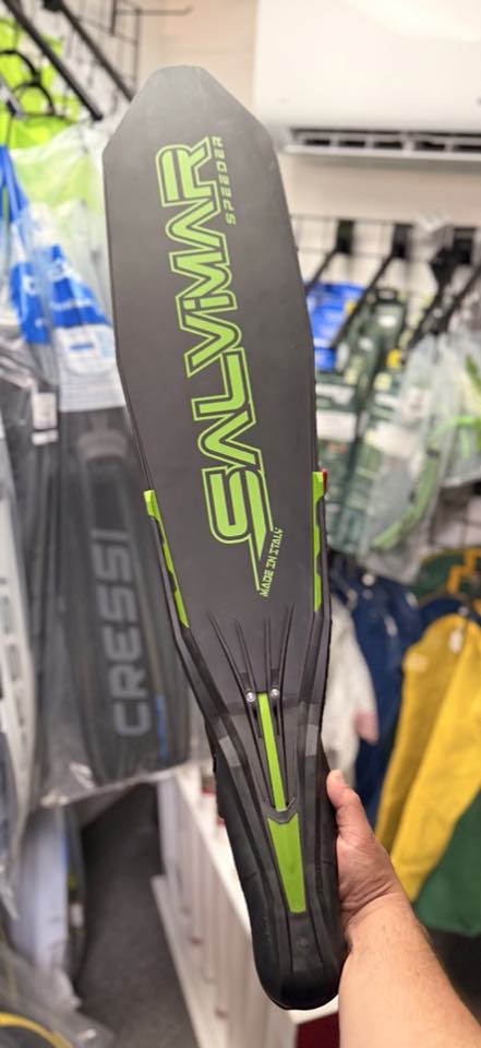 A long-blade Salvimar freediving fin held up in the shop