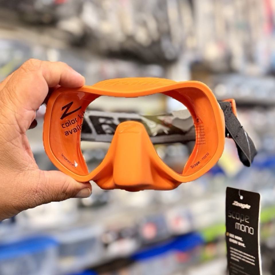 An orange Zeagle frameless mask held up in the shop