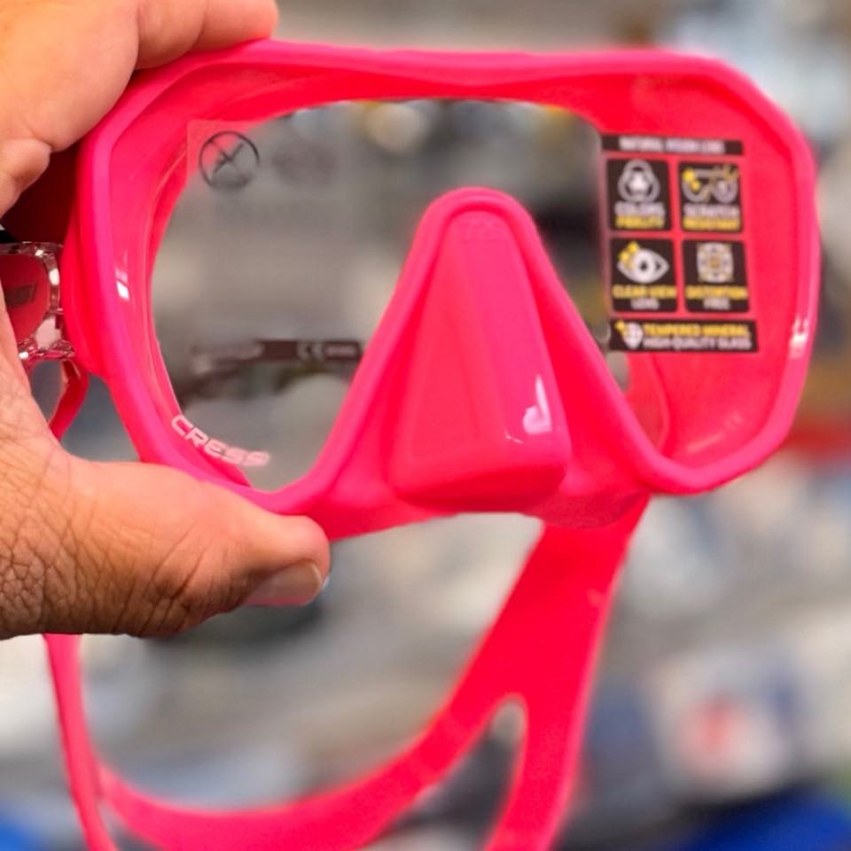 A pink frameless mask held up in the shop
