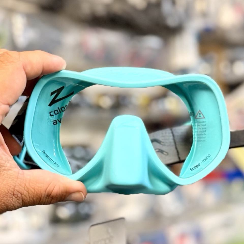 A turquoise Zeagle frameless mask held up in the shop