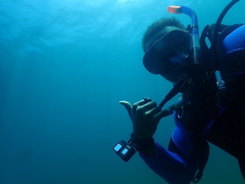 Un buzo fotografiando con una cámara bajo el agua