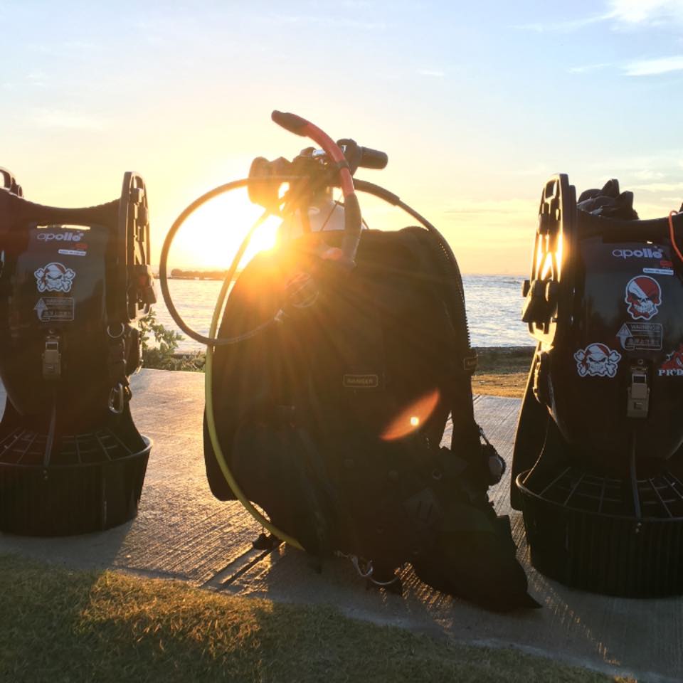 Dive gear set up on shore at sunset, ready for a shore dive