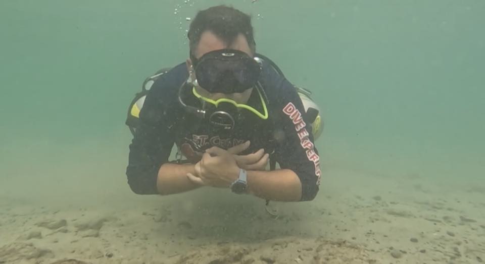 Un buzo flotando en agua azul después de un curso